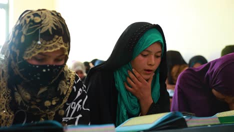 Muslim-Afghan-girls-studying-the-Quran,-a-hijab-wearing-girl,-a-Muslim-girl-in-prayer