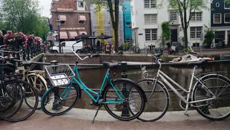 Amsterdam-Canal-Bridge-With-Bicycles-And-Canal-Houses-In-Netherlands,-Europe