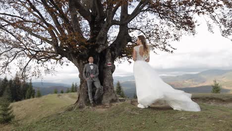 Lovely-caucasian-wedding-couple-newlyweds-family-bride-groom-stay-together-on-mountain-slope-hill