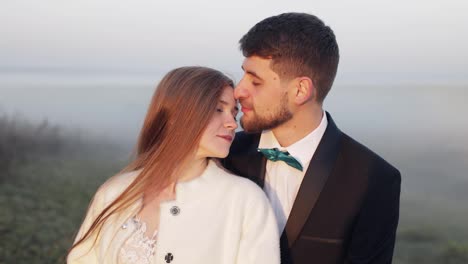 Newlyweds.-Caucasian-groom-with-bride-on-the-morning-field.-Fog.-Wedding-couple