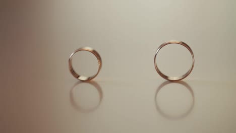 Wedding-gold-rings-roll-to-each-other.-Close-up,-macro-shot