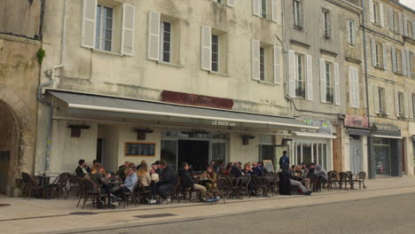 Many-people-sitting-in-a-bar-terrace-of-La-Rochelle,-France