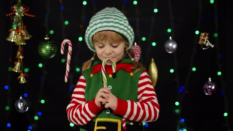 Kind-Mädchen-In-Weihnachten-Elf-Santa-Claus-Helfer-Kostüm-Leckt-Zuckerstange-Lutscher-Karamell-Süßigkeiten