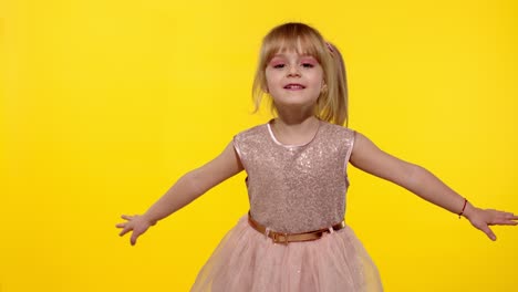 Little-blonde-child-girl-5-6-years-old-flying,-dancing,-celebrating-on-yellow-studio-background