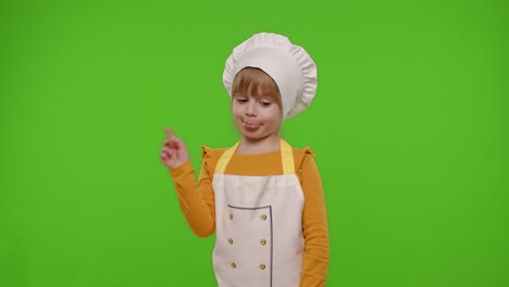 Kid-girl-dressed-as-cook-chef-baker-in-apron-dancing,-fooling-around,-showing-tongue,-chroma-key