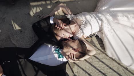 Newlyweds.-Caucasian-groom-with-bride-lie-on-the-ground-next-to-each-other