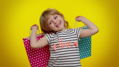 Kid-girl-showing-shopping-bags,-advertising-discounts,-low-prices,-shopping-on-Black-Friday-holidays