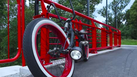 Footage-shows-a-big-black-chopper-styled-bike-or-a-bicycle-on-a-bridge-with-whitewall-wheels-and-a-big-headlights-that-is-on