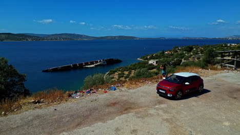 Una-Mujer-Fotografía-Los-Restos-Del-MS-Mediterranean-Sky-En-Palea-Eo-Athinon-Korinthou,-Grecia.-Un-Dron-Vuela-Hacia-Adelante.