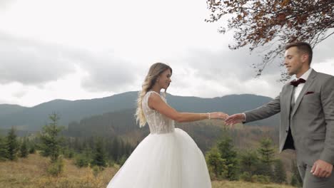 Lovely-newlyweds-bride-groom-dancing-on-mountain-autumn-slope-in-slow-motion,-wedding-couple-family