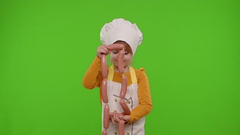 Child-girl-dressed-as-cook-chef-in-apron-puts-on-a-bunch-of-sausages-around-her-neck,-fooling-around