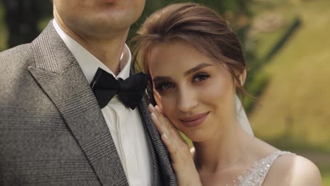 Newlyweds,-bride-woman-lying-on-her-husband-shoulder-and-looking-at-camera,-happy-wedding-couple