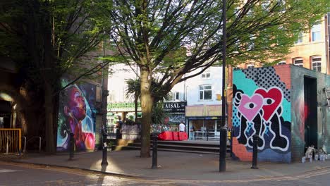 Street-art-murals-in-vibrant-Northern-Quarter-of-Manchester-with-bars-and-shops-in-view