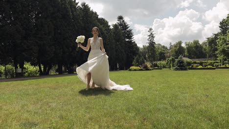 Hermosa-Novia-Elegante-Con-Vestido-De-Novia-Blanco-Y-Velo-Sosteniendo-Ramo-De-Novia-En-Las-Manos-En-El-Parque