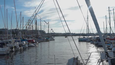 Footage-of-vintage-and-small-yachts,-boats-and-ships-at-a-harbor-docked-with-flags-on-their-masts-waving-in-slow-motion-during-the-summer-time-in-4K-resolution-in-Tallinn-Estonia-Europe