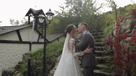 Lovely-newlyweds-caucasian-bride-embracing-groom-in-park-making-kiss,-wedding-couple-family-hugging