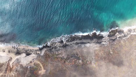 Vista-Aérea-De-Arriba-Hacia-Abajo,-Playa-Desierta-En-Isla-Volcánica-Y-Olas-Del-Océano,-Toma-Aérea-Con-Dron-De-ángulo-Alto-A-60-Fps