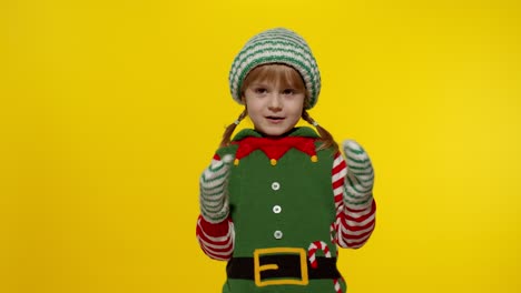 Kid-girl-in-Christmas-elf-Santa-helper-costume-dancing,-fooling-around.-New-Year-holiday-celebration