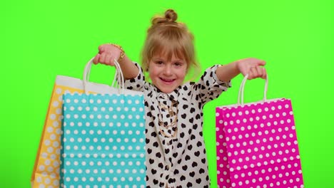 Niña-Mostrando-Bolsas-De-Compras,-Descuentos-Publicitarios,-Precios-Bajos,-Compras-En-Los-Días-Festivos-Del-Viernes-Negro