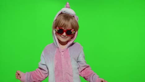 Little-blonde-child-girl-smiling,-dancing,-celebrating-in-unicorn-pajamas-costume-on-chroma-key