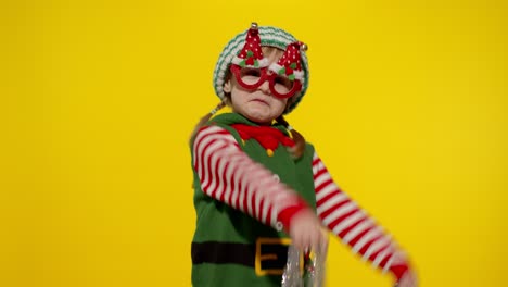 Kid-girl-in-Christmas-elf-Santa-helper-costume-dancing,-fooling-around.-New-Year-holiday-celebration