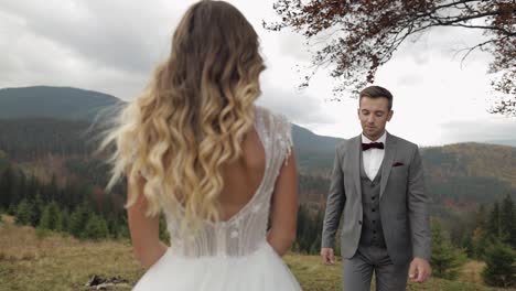 Lovely-young-newlyweds-bride-groom-embracing-on-mountain-slope,-happy-wedding-couple-family-in-love