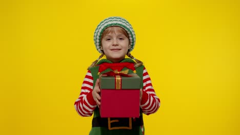 Kid-girl-Christmas-elf-Santa-helper-giving-present-gift-box-to-camera.-Happy-New-Year-holidays