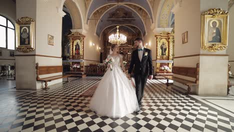 Newlyweds.-Caucasian-bride-and-groom-walking-together-in-an-old-church.-Wedding