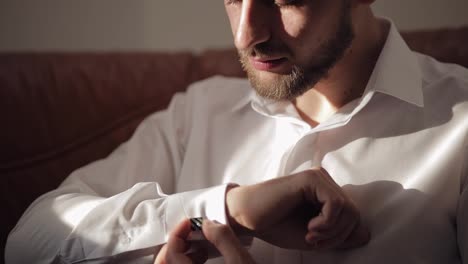 Handsome-groom-man-fixes-his-cuffs-on-a-jacket-with-cufflinks.-Businessman