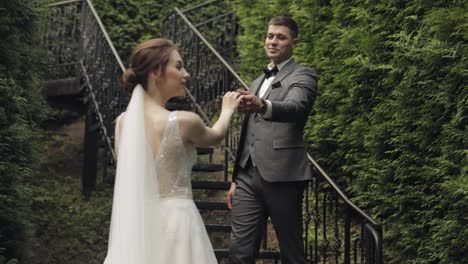 Newlyweds,-caucasian-groom-with-bride-stay-on-stairs-in-park,-wedding-couple,-man-and-woman-in-love