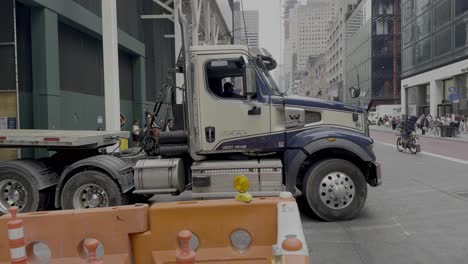 A-street-level-shot-of-a-tractor-trailer-without-a-load-backing-into-a-loading-dock-on-Fifth-Avenue-in-NYC-on-a-cloudy-day