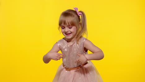 Little-blonde-child-girl-5-6-years-old-smiling,-dancing,-celebrating-on-yellow-studio-background