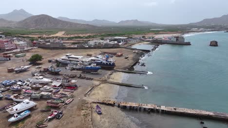 Mindelo,-Sao-Vicente,-Cape-Verde,-Drone-Shot-of-Old-Ships,-Boats-and-Buildings-by-City-Harbor-60fps