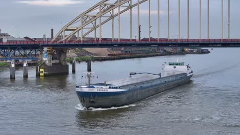 PRIMAIR-Cargo-Ship-Passing-Under-The-Bridge-In-Alblasserdam,-Netherlands---Drone-Shot