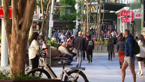 Urban-street-scene-of-downtown-Brisbane-city,-shoppers-shopping-at-Queen-street-mall,-people-strolling-at-the-outdoor-pedestrian-shopping-precinct,-concept-of-inflation-and-cost-of-living