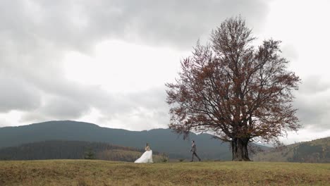 Lovely-newlyweds-bride-groom-dancing-on-mountain-autumn-slope-in-slow-motion,-wedding-couple-family