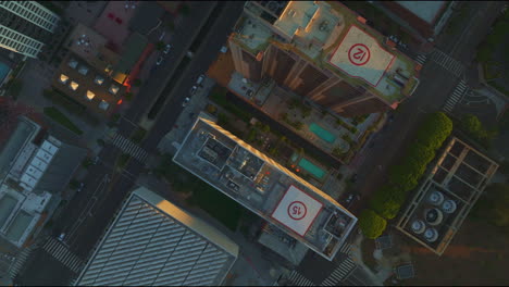 Top-down-aerial-view-of-downtown-Los-Angeles,-showcasing-rooftops-and-streets-with-car-traffic,-emphasizing-the-city's-vibrant-urban-movement