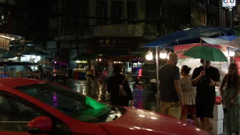 Bustling-Chinatown-street-in-Bangkok-at-night-with-food-stalls-and-tuk-tuks-reflecting-neon-lights