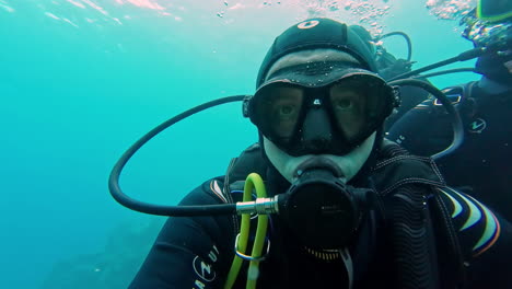 Face-view-of-snorkeler-under-sea-wearing-oxygen-mask-and-goggles-in-Greece