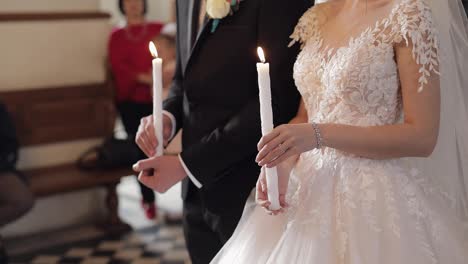 Los-Recién-Casados,-La-Novia-Y-El-Novio,-Están-En-La-Iglesia,-Sosteniendo-Velas-En-Sus-Manos.