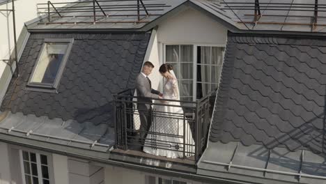 Caucasian-newlyweds-bride-embracing-groom-on-balcony-in-hotel-room,-aerial-view