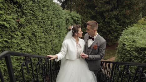 Newlyweds,-caucasian-groom-with-bride-stay-on-stairs-in-park,-wedding-couple,-man-and-woman-in-love