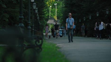 People-strolling-along-a-shaded-pathway-at-Zagreb-Zoo,-Croatia