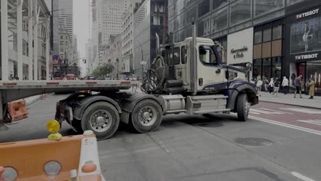 A-street-level-shot-of-a-tractor-trailer-without-a-load-backing-into-a-loading-dock-on-Fifth-Avenue-in-NYC-on-a-cloudy-day