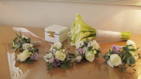 Beautiful-wedding-bouquets-lie-on-a-table-near-box-with-wedding-rings