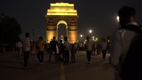 Multitud-De-Turistas-Disfrutando-De-La-Vista-Nocturna-De-La-Puerta-De-La-India-Iluminada-Con-Hermosas-Luces