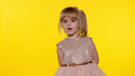 Niña-Pequeña-De-5-A-6-Años-Sonriendo,-Bailando,-Girando-En-Su-Lugar-Sobre-Fondo-Amarillo-De-Estudio