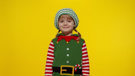 Kid-girl-in-Christmas-elf-Santa-helper-costume-dancing,-performing-dab-dance,-internet-meme-gesture