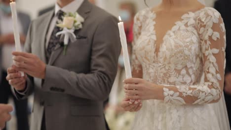 Los-Recién-Casados,-La-Novia-Y-El-Novio-Están-De-Pie-En-La-Iglesia,-Sosteniendo-Velas-En-Sus-Manos.-Ceremonia-De-Boda