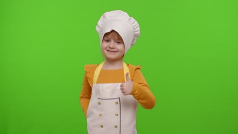 Child-girl-kid-dressed-as-cook-chef-showing-thumbs-up,-smiling,-looking-at-camera-on-chroma-key